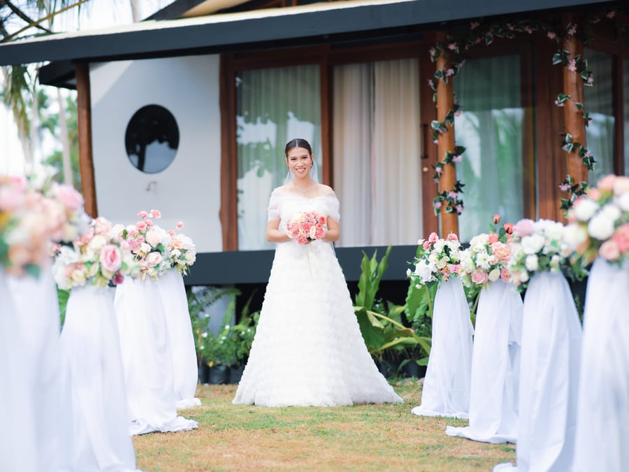 Bride walking the aisle at BAIBAI Beach Resort wedding ceremony