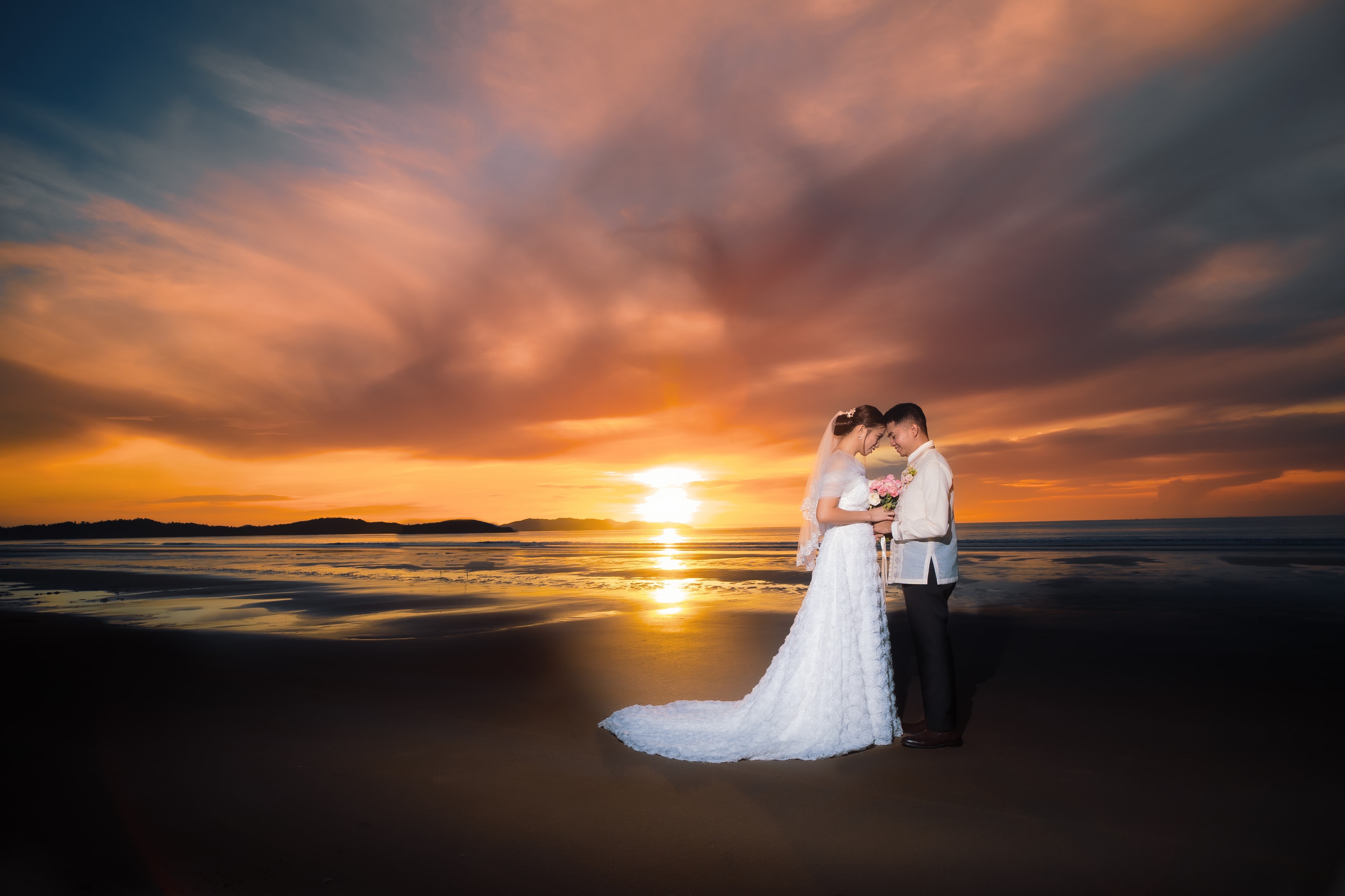 Bride and groom at sunset on Long Beach, San Vicente Palawan